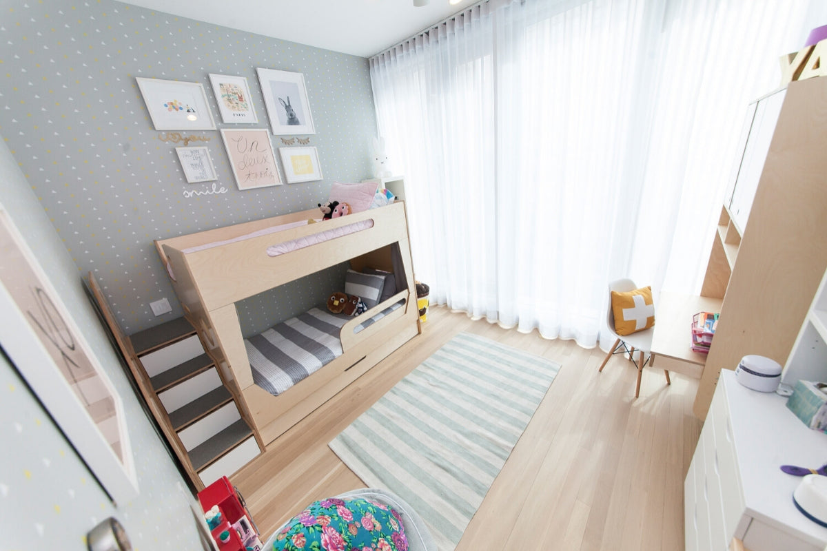 Child’s bedroom with bunk bed, toys, and wall art.
