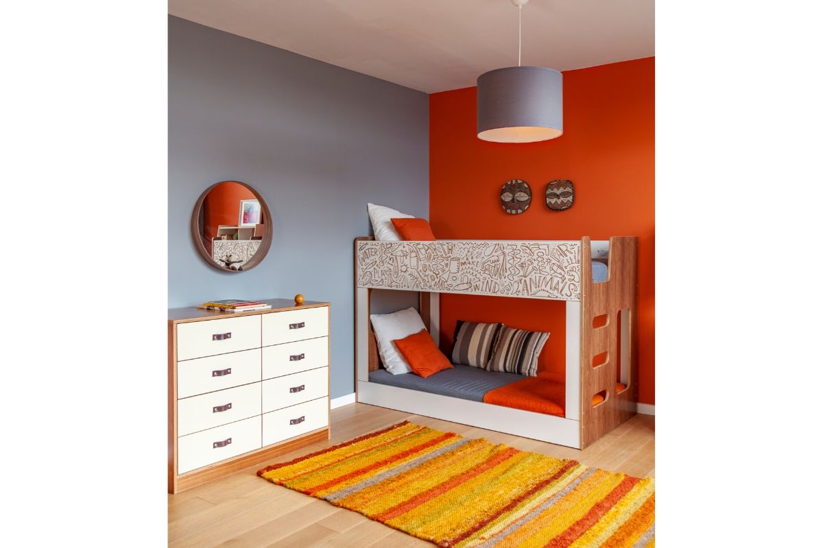 Modern room with bunk bed, dresser, rug, wall plates.