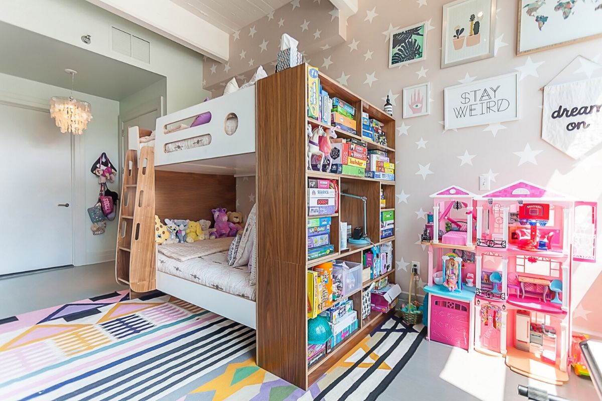 Vibrant child’s bedroom with bunk bed, bookshelf, toys, and wall art.