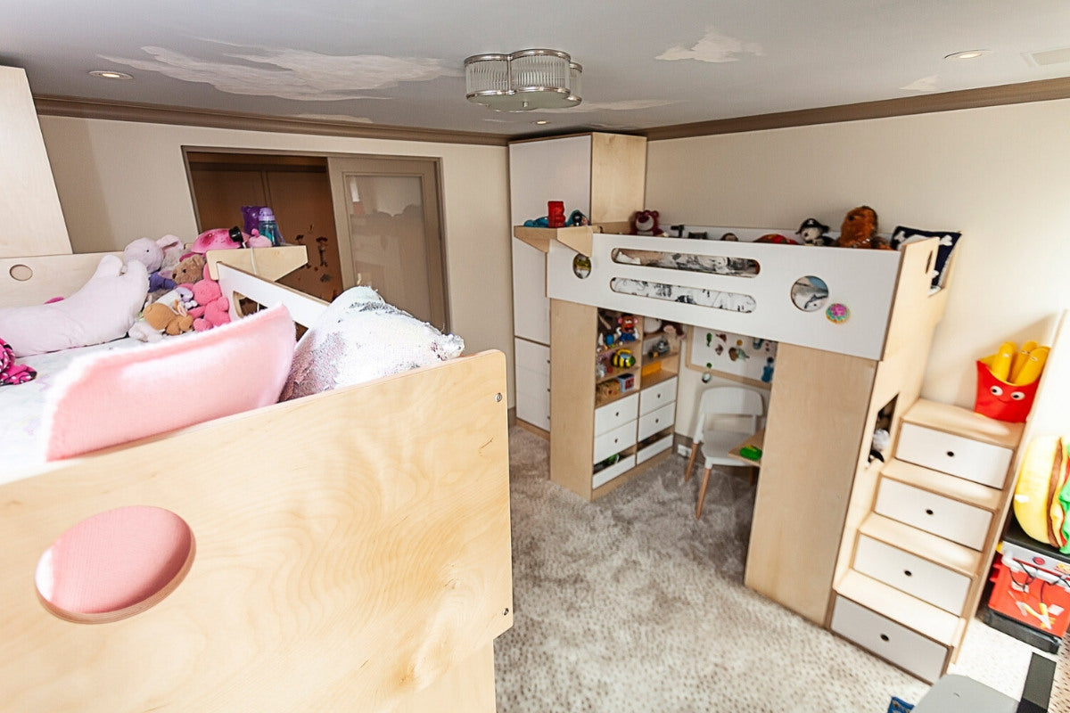 Child's room with loft bed, desk, toys, and plush animals.