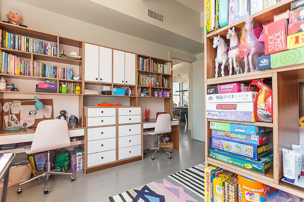 Home office with desk, chair, bookshelves, and board games.