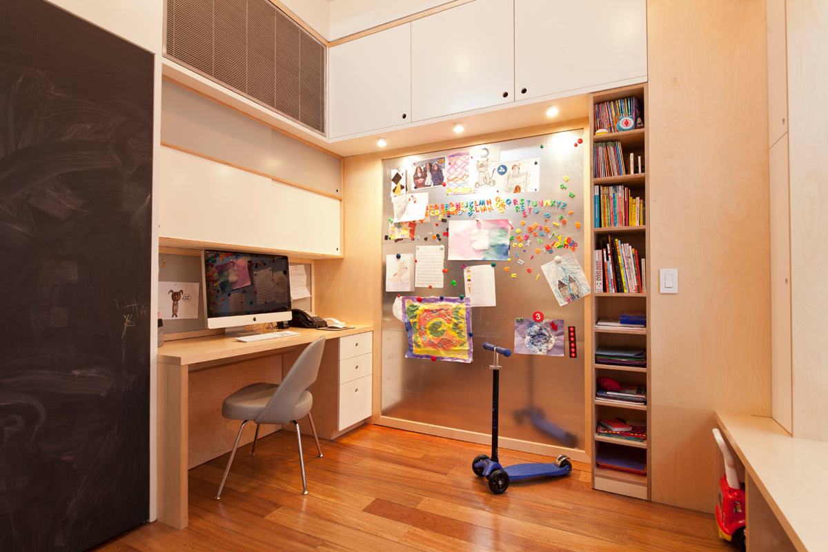 Child’s study room with desk, computer, shelves, and organized space.