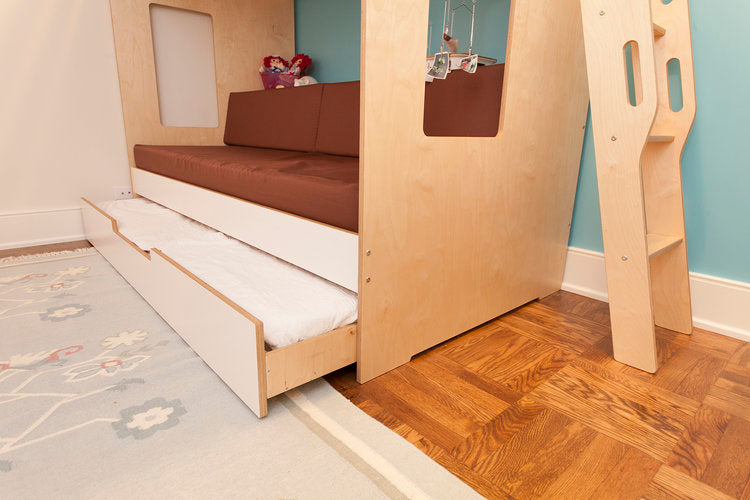 Wooden trundle bed partially extended in a child's room, with a decorative rug on hardwood flooring. 
