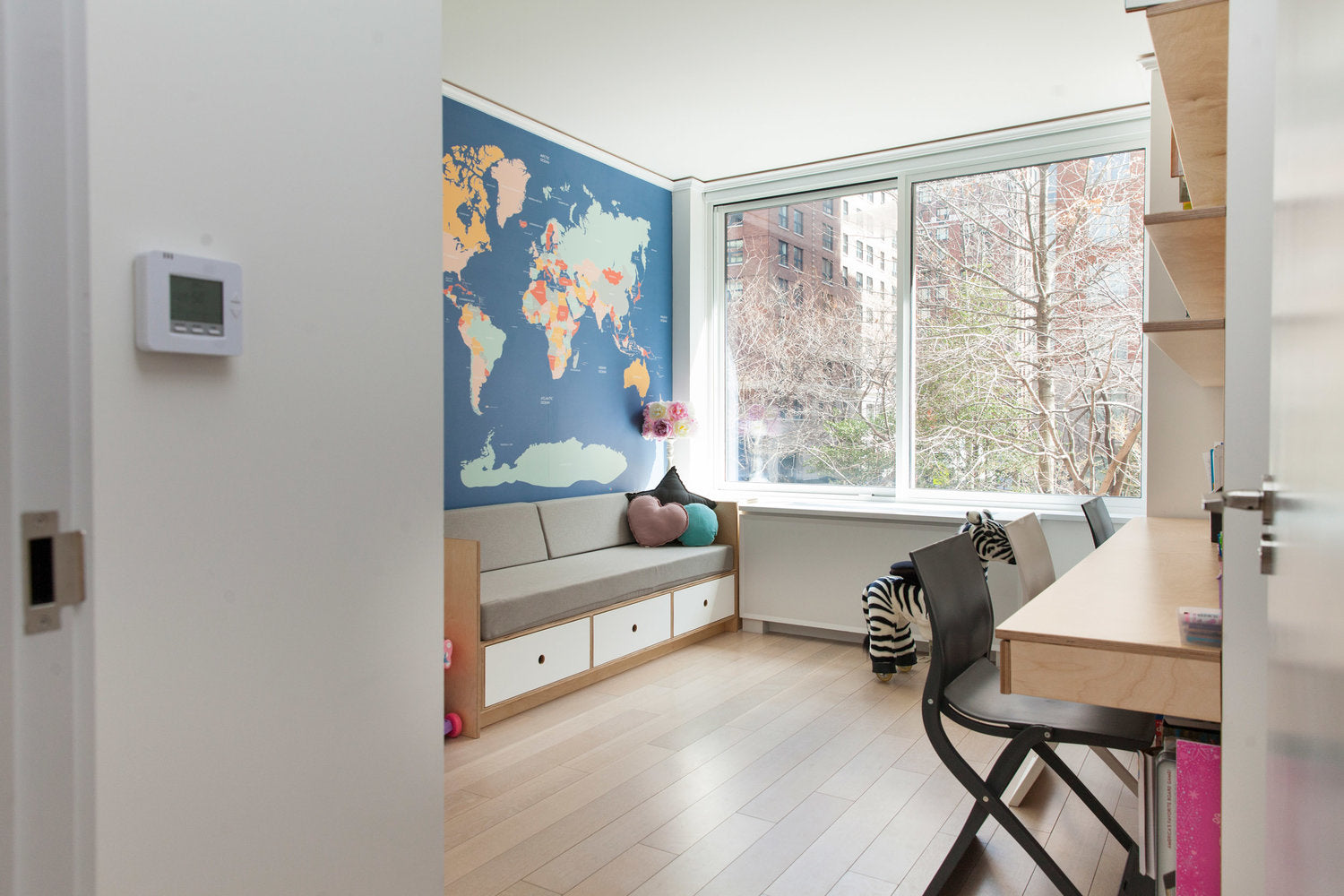 Modern room with world map, desk, and window view.