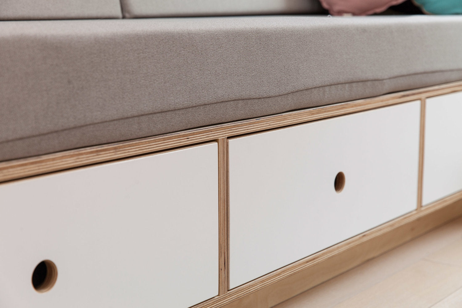Close-up of a modern sofa with built-in white drawers.