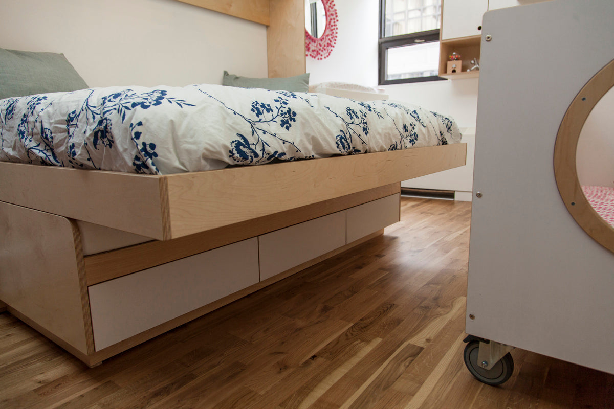 Minimalist bedroom with a modern bed featuring storage drawers.