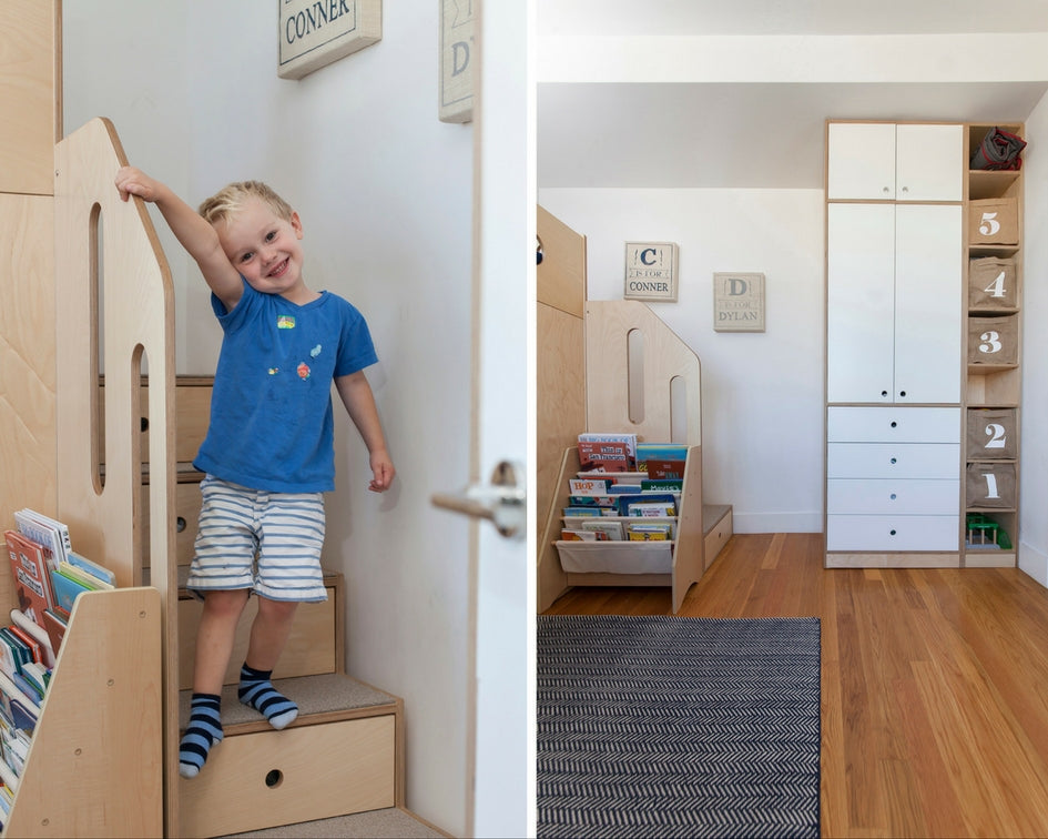 Child in blue shirt by bookshelf and labeled drawers.