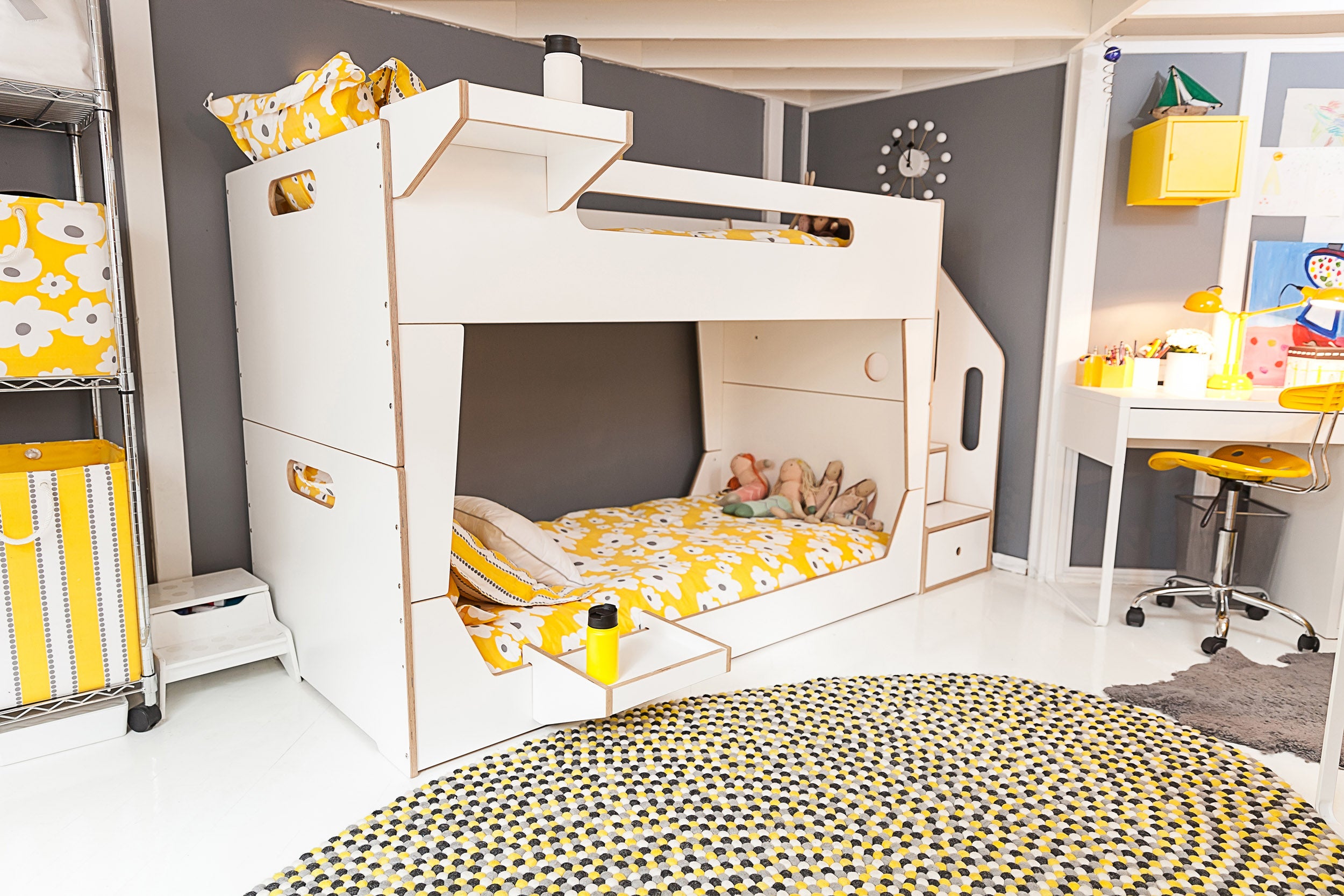 Modern children’s room, white bunk bed, yellow accents, polka dot rug.