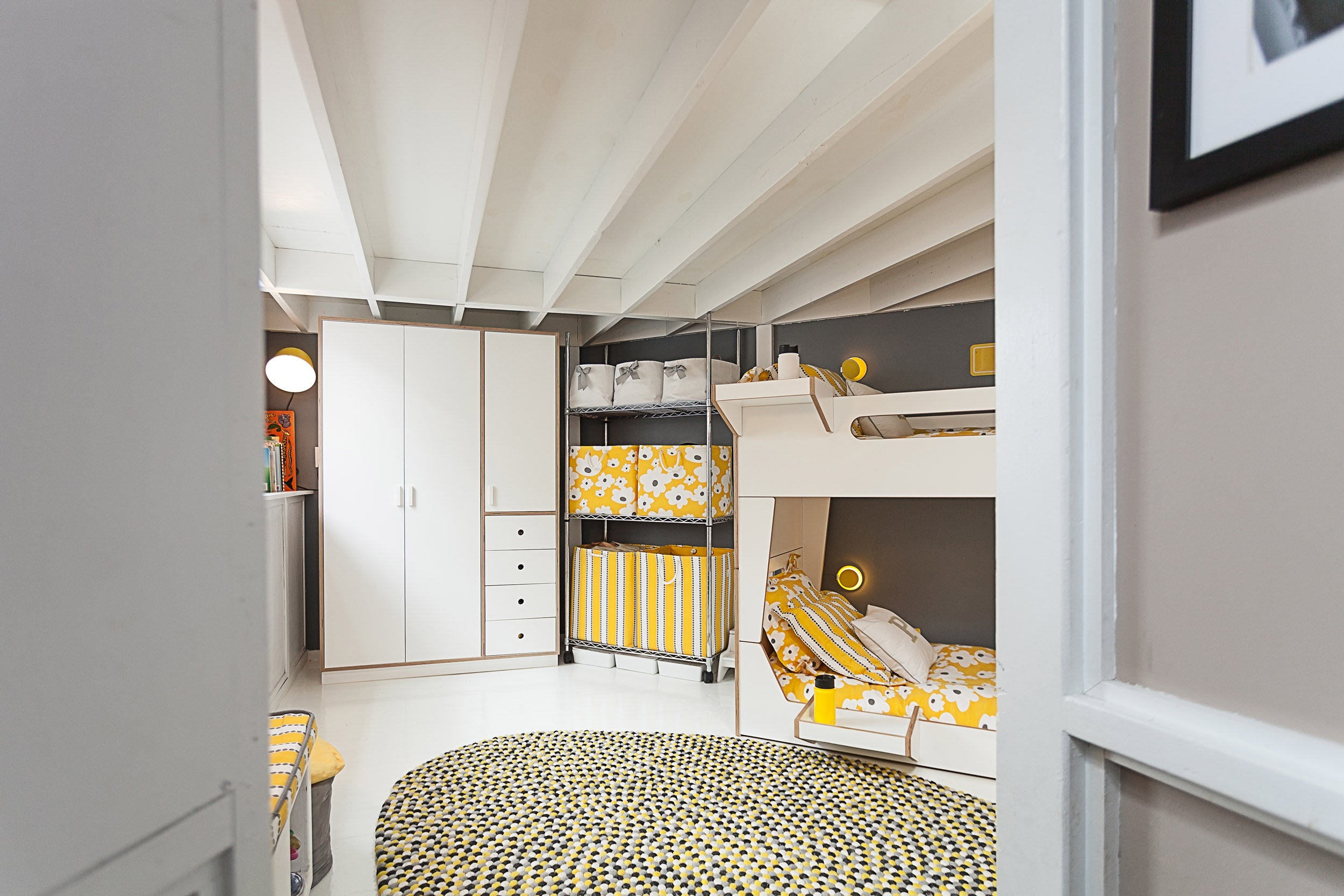 Cozy bedroom with bunk beds, yellow accents, and storage.