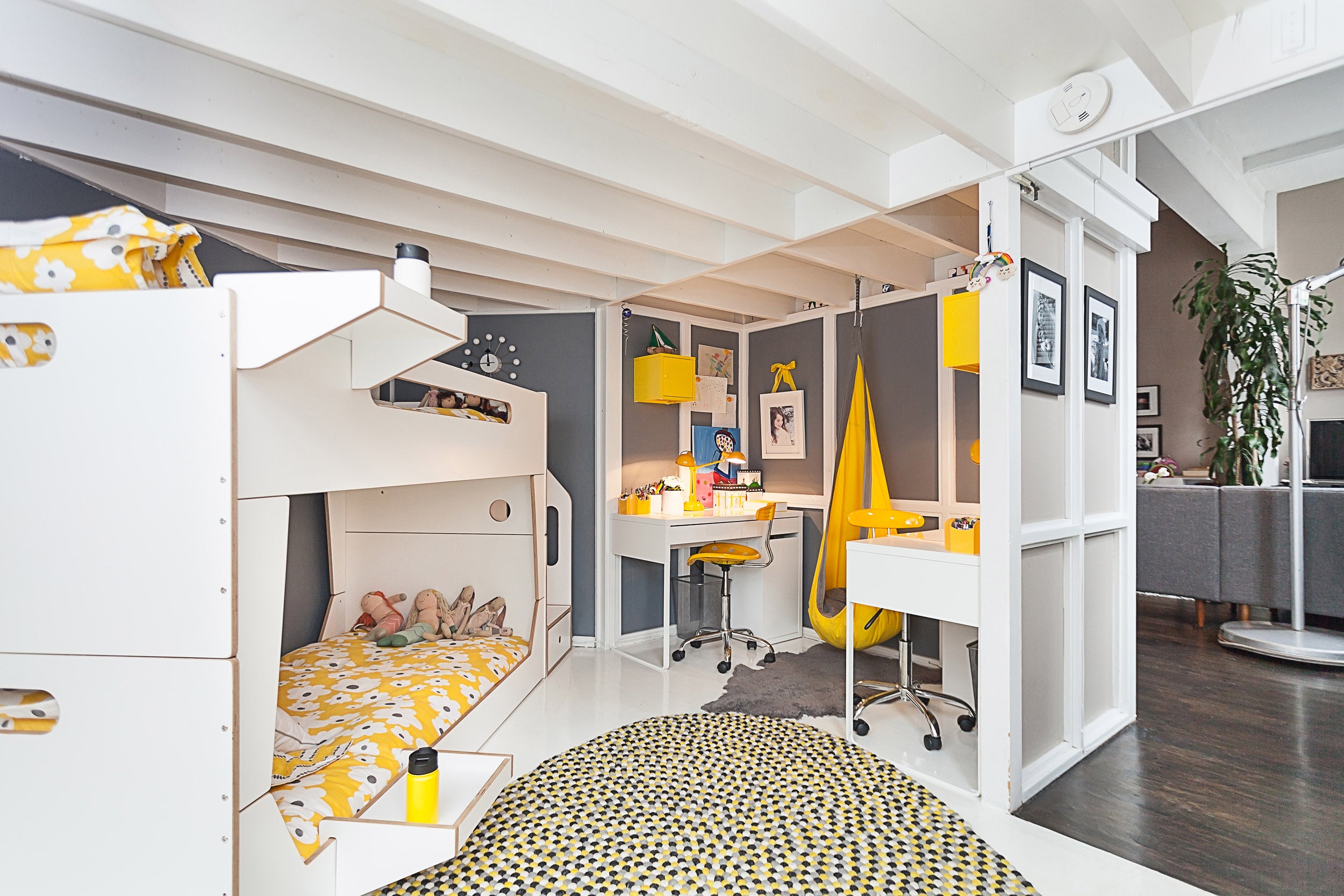 Modern room, white/yellow bunk bed, desk, chair, polka dot rug.