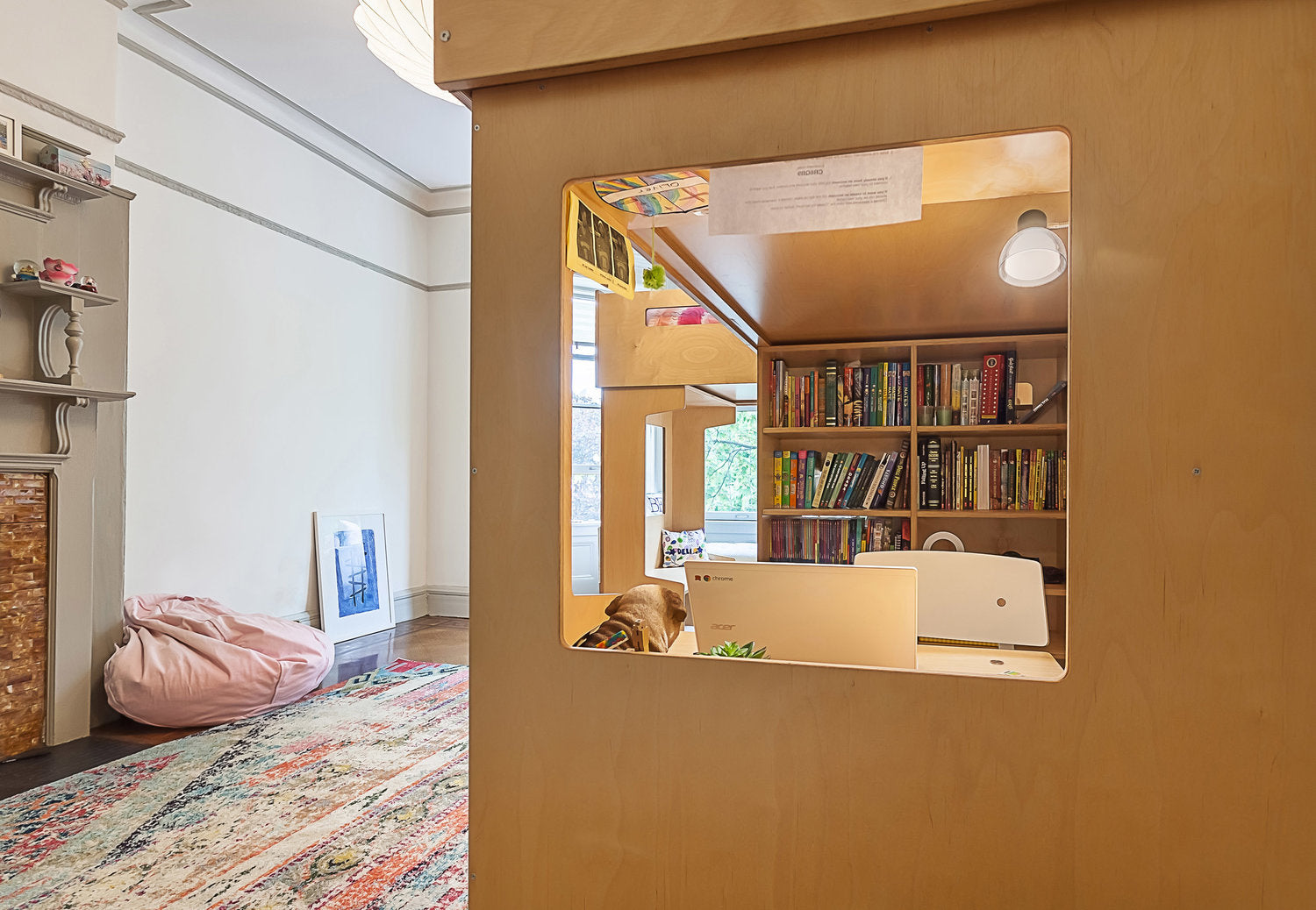 Cozy room with desk, bookshelf, bean bag, colorful rug through square cutout.