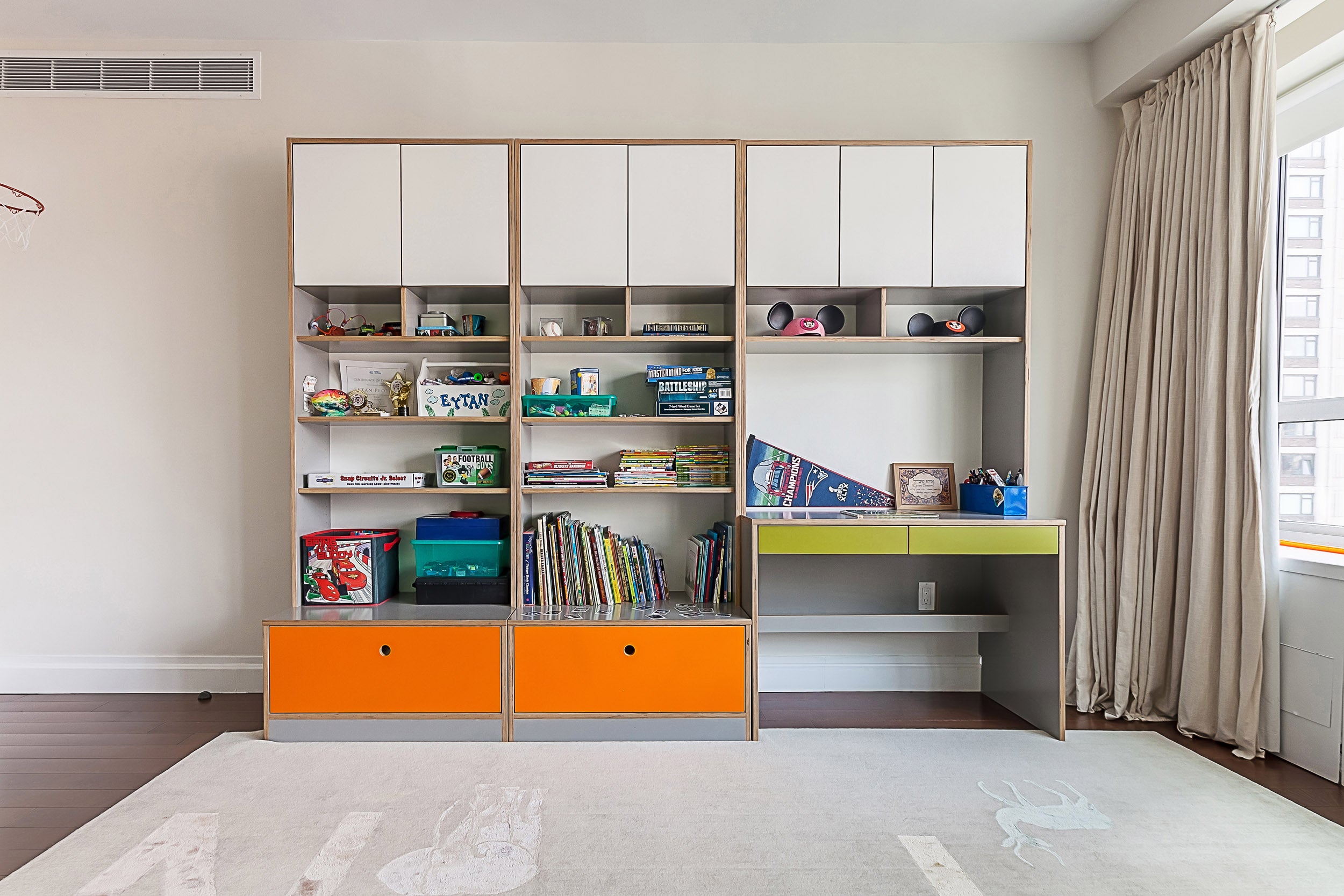 “Modern room with shelving, colorful bins, books, desk area.