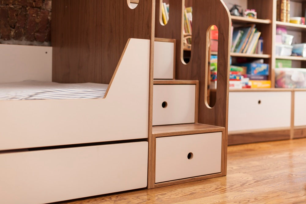 Colorful books, globe, and storage cabinets on wooden bookshelf.