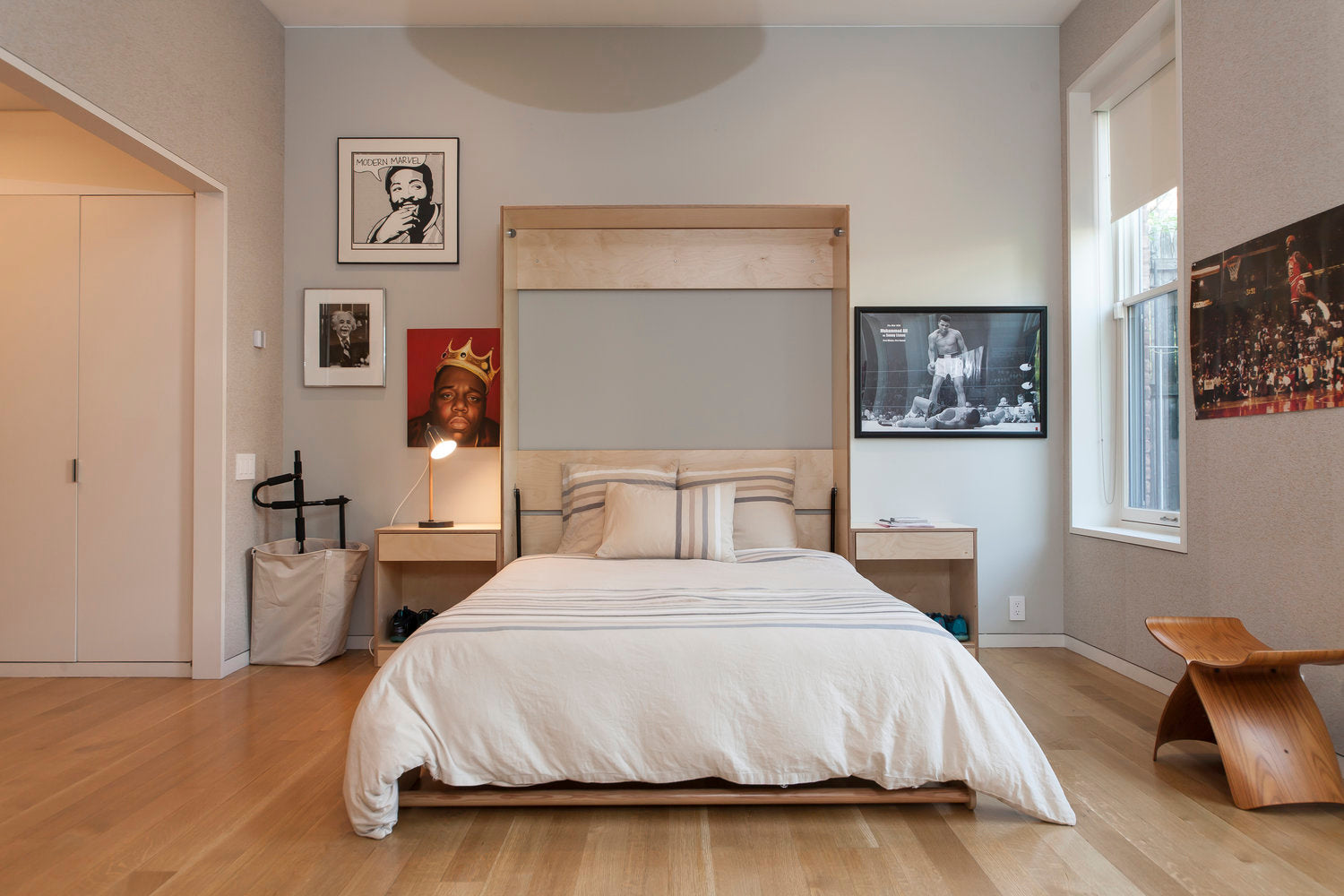 Bedroom with large bed, wooden floor, wall TV.