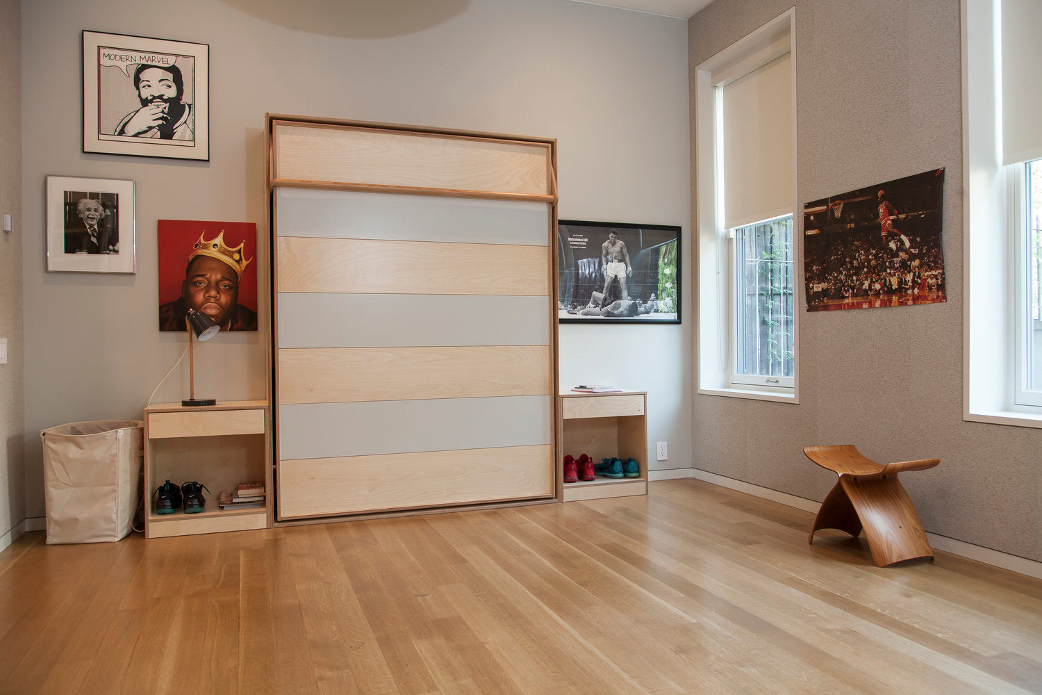 Modern room with Murphy bed, desk, chair, wall art, and ambient lighting.