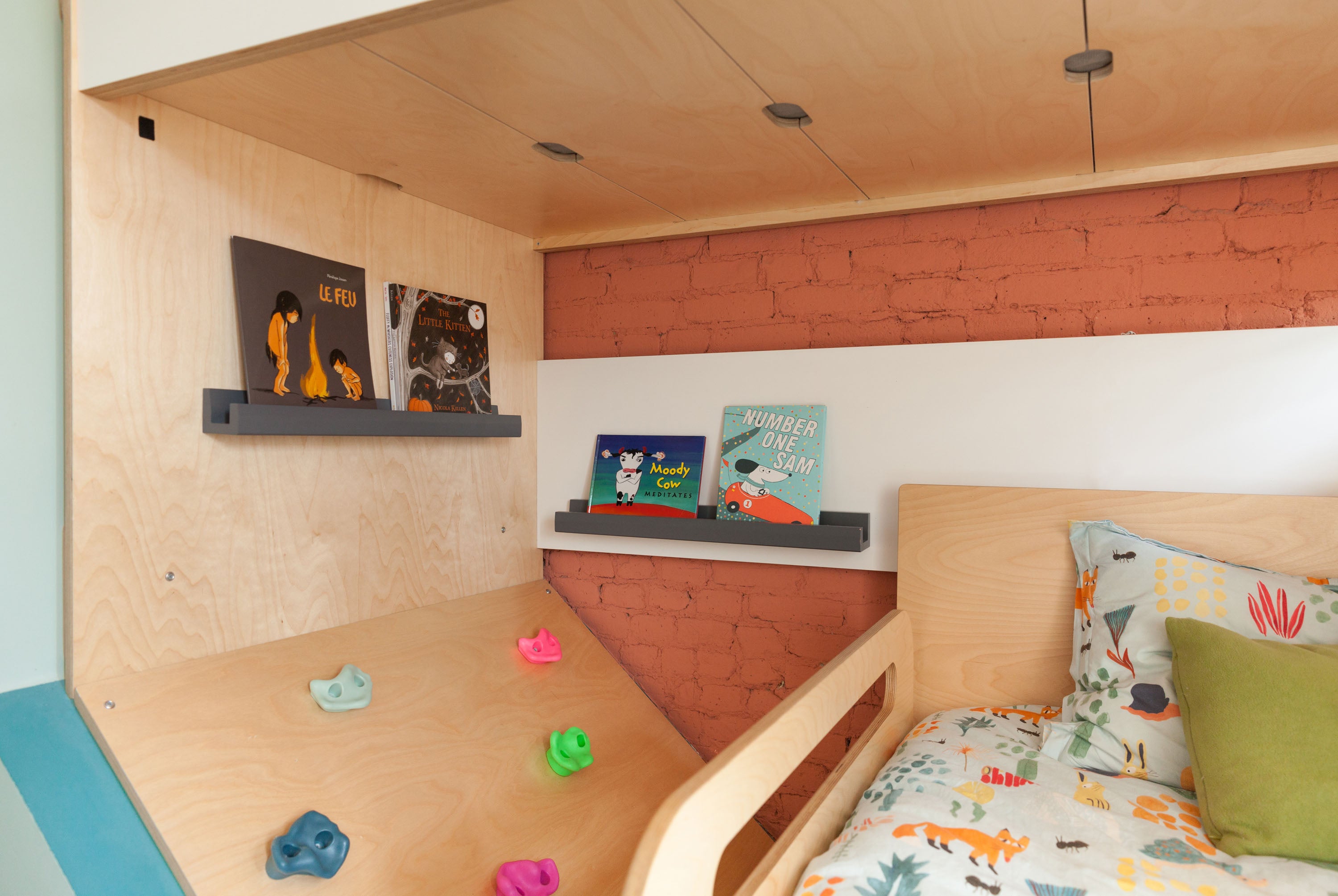 Modern bedroom with wooden bunk bed and colorful wall holds.