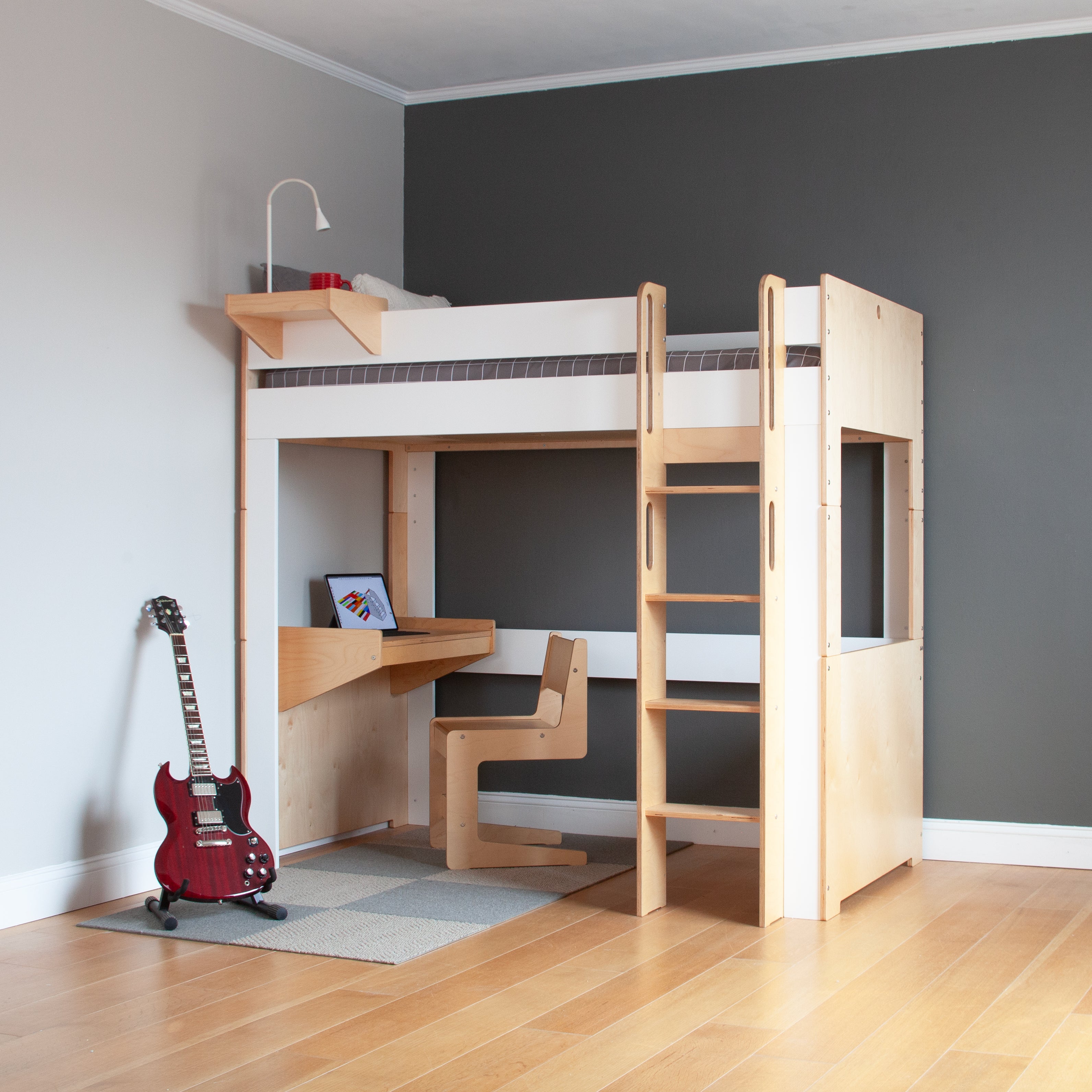 Modern loft bed with desk and staircase, gray walls, and a red electric guitar on the floor.