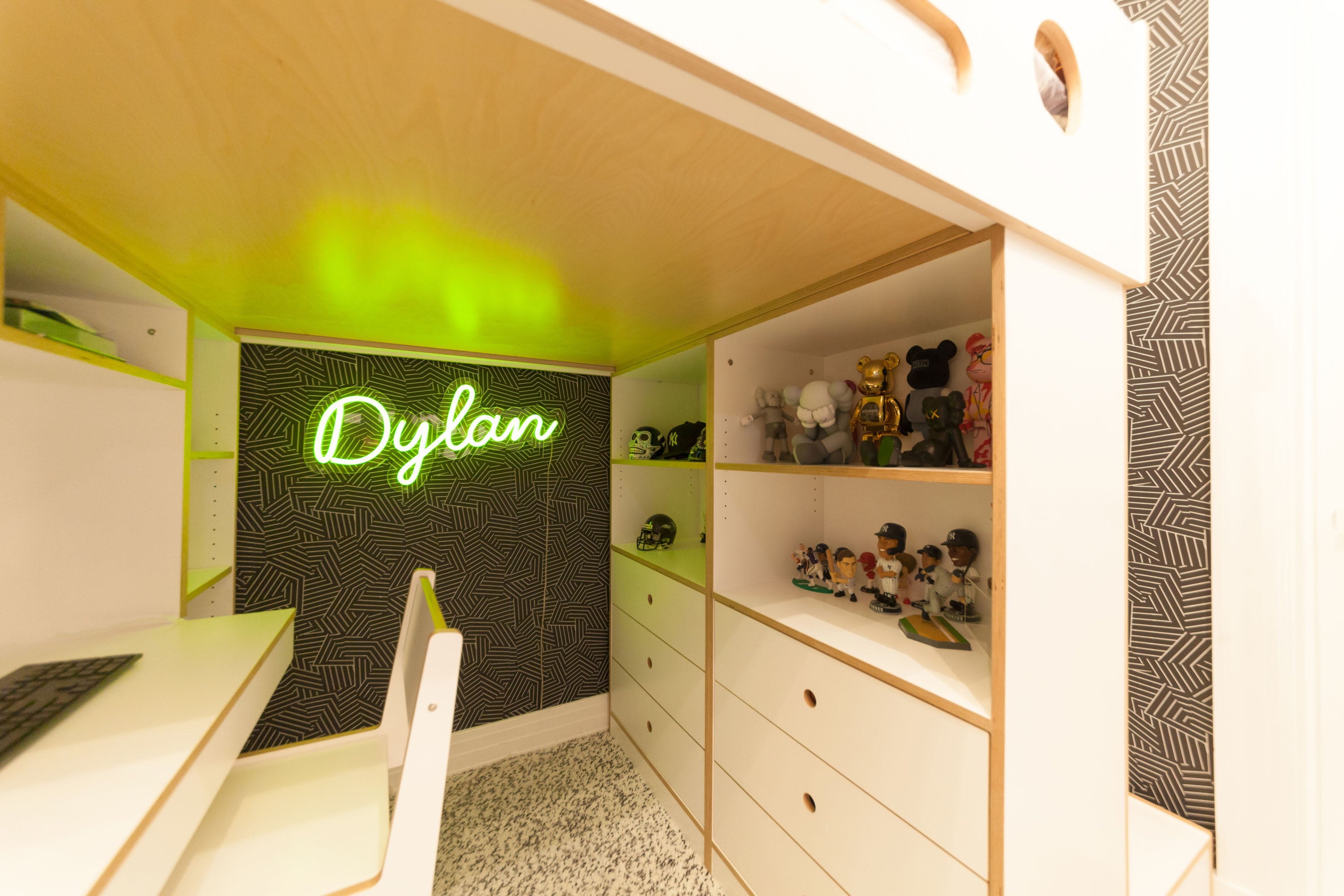 Neon ‘Dylan’ sign, cozy room, shelves, collectibles, desk.