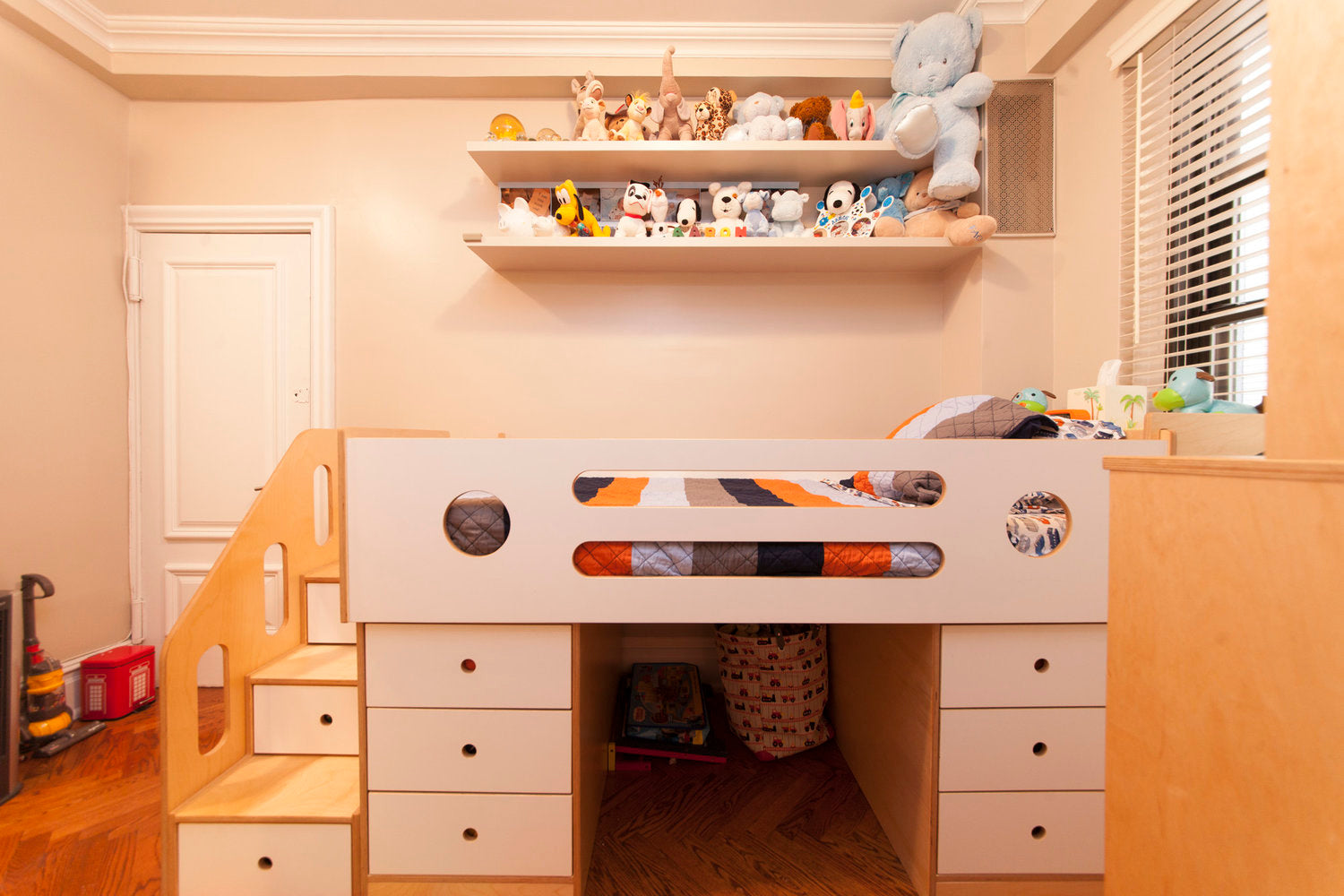 Child’s room with bed, toys on shelves, and play area.