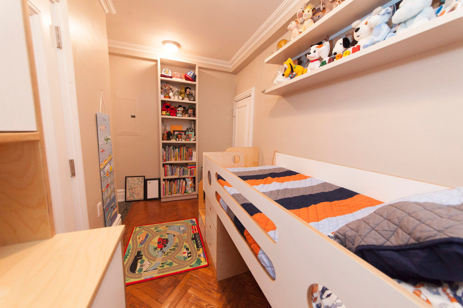 Child’s room with bed, toys, bookshelf, play mat.