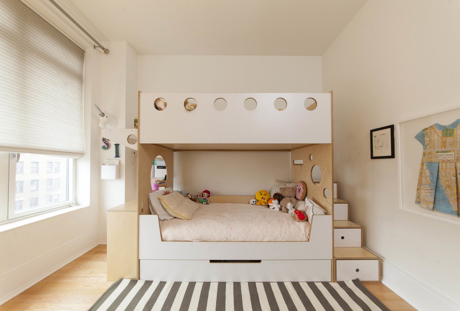 Cozy children's room with a modern bunk bed, stuffed animals, and a striped rug.