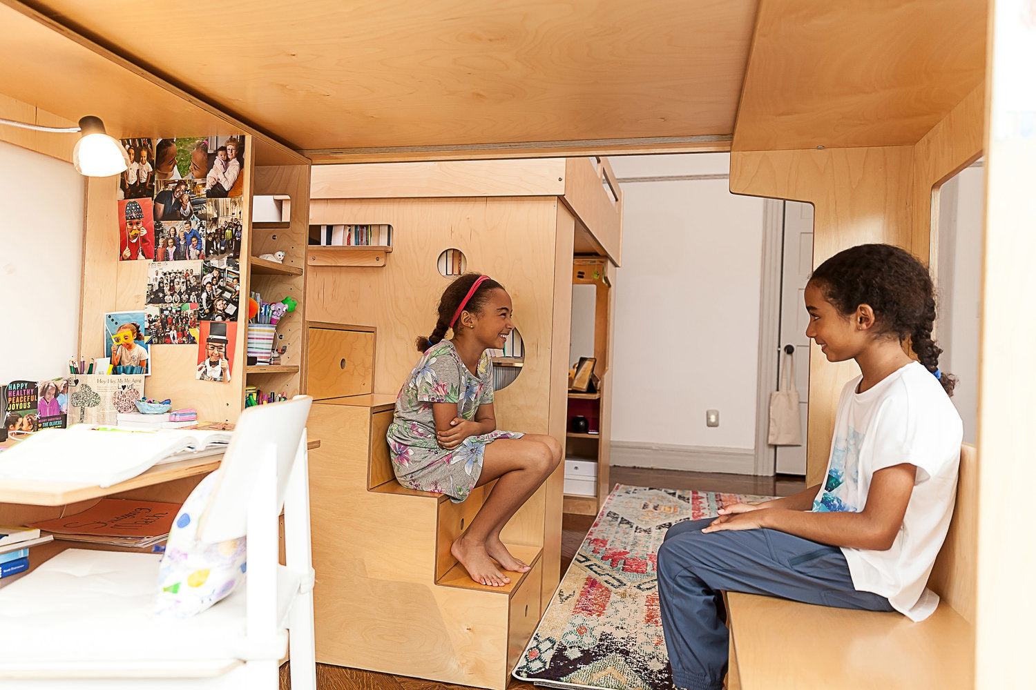 Cozy room with desk, bookshelf, bean bag, colorful rug through square cutout.