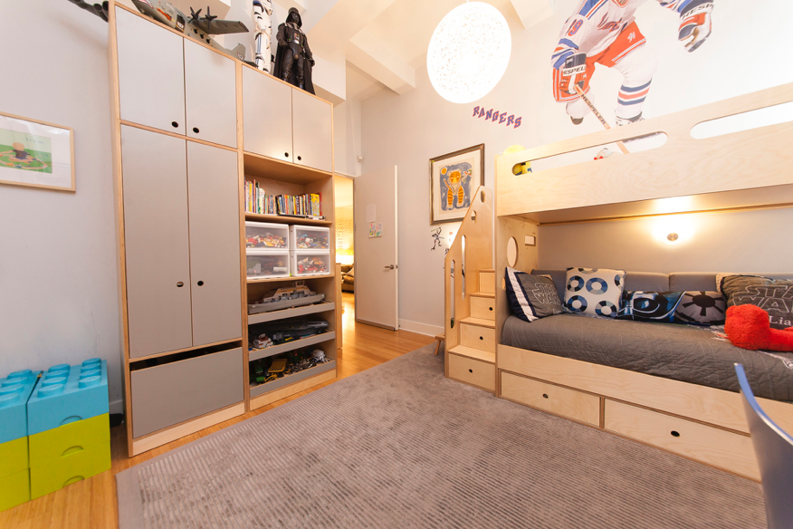 Child’s room with bunk bed, shelves, sports decor, and toys.