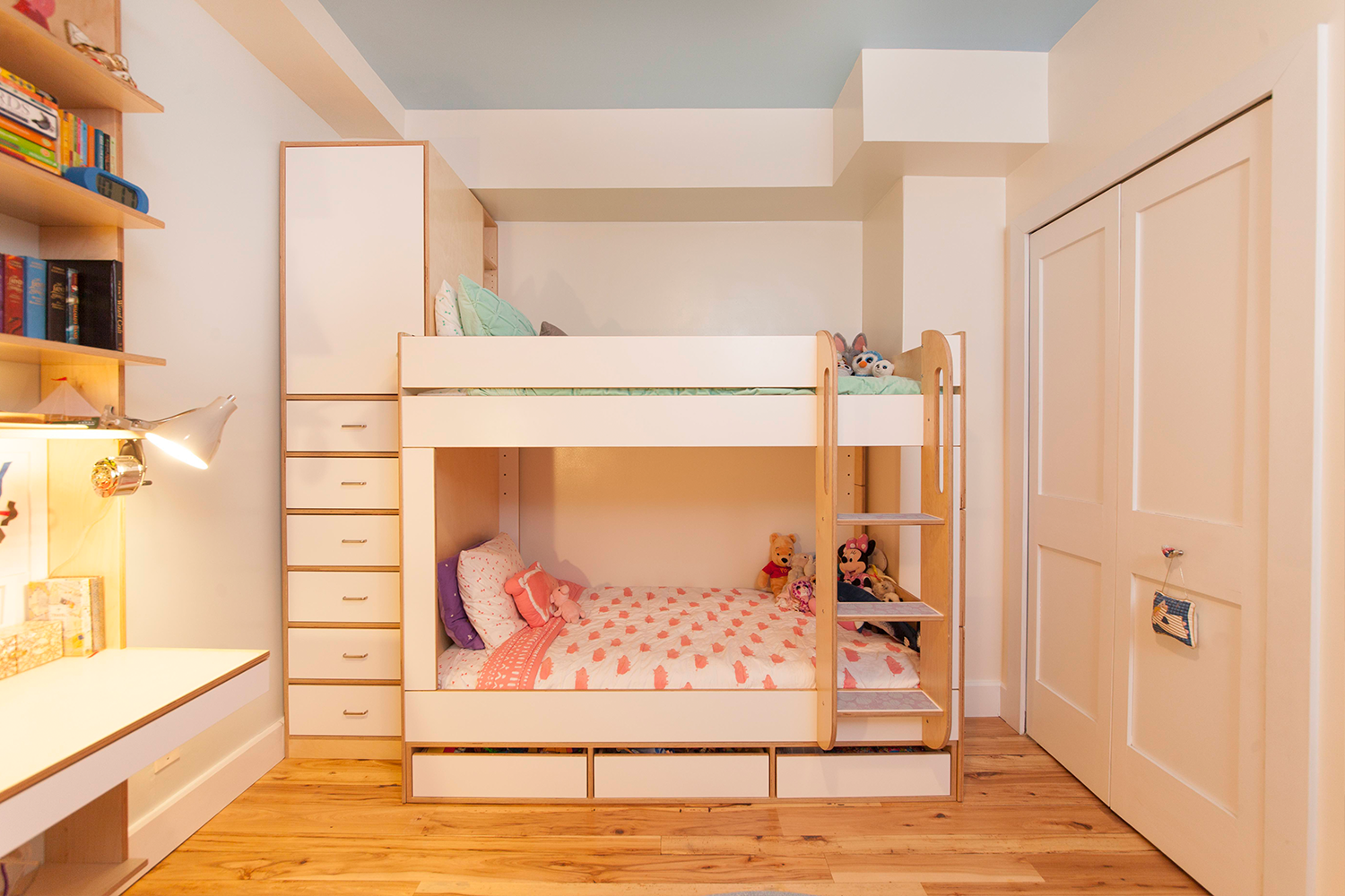 Children’s bedroom with bunk bed, toys, and wooden furniture.