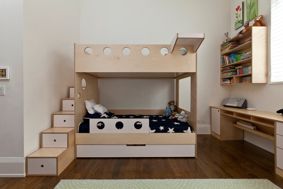 Minimalist children's room with a wooden bunk bed, built-in desk, bookshelf, and star-patterned bedding.