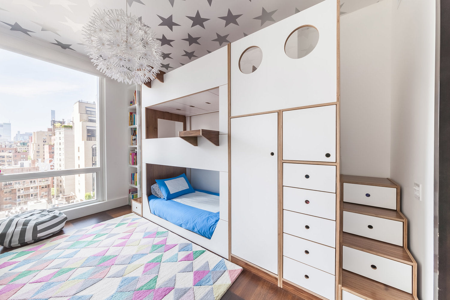 Modern kids’ bedroom with bunk bed, star ceiling, and colorful rug.