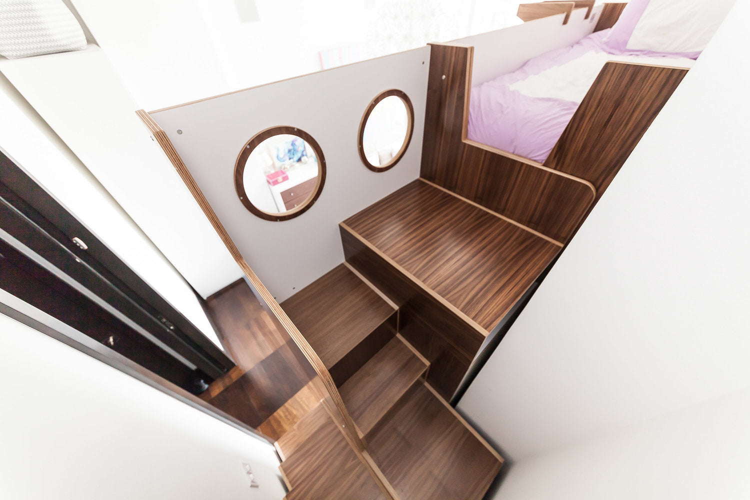 Loft bed with storage stairs in a cozy room.