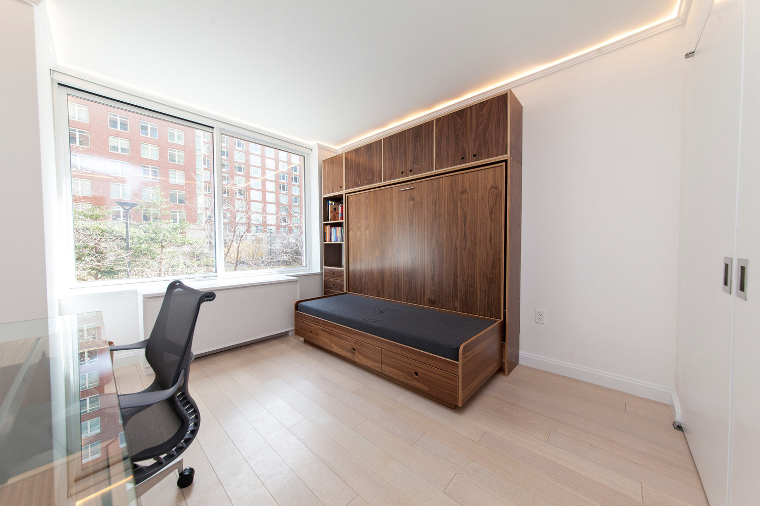 Modern room with a cabinet bed, large window, and an office chair.