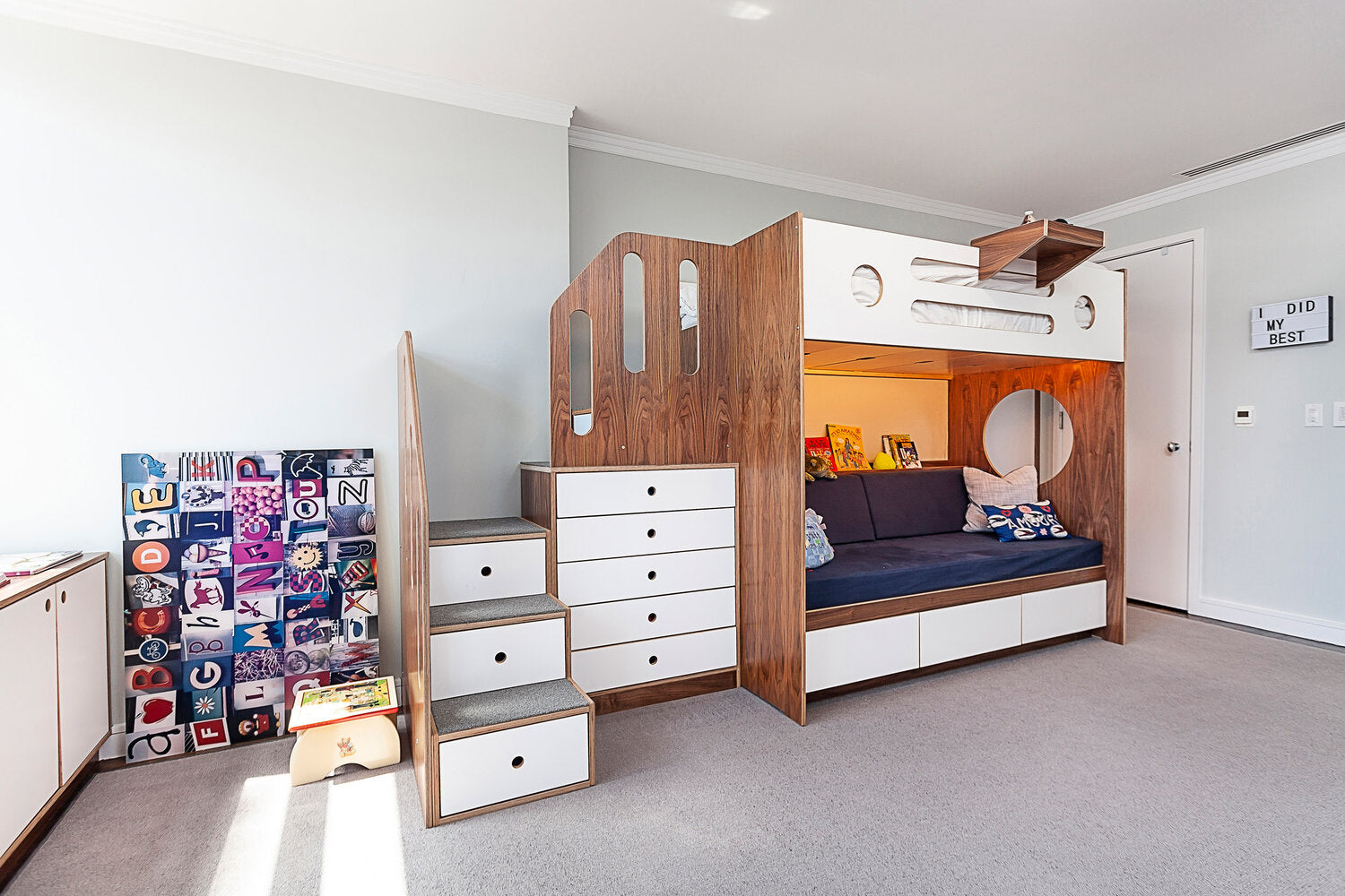 Modern kids’ room with bunk bed, built-in shelves, and skateboard deck wall art.