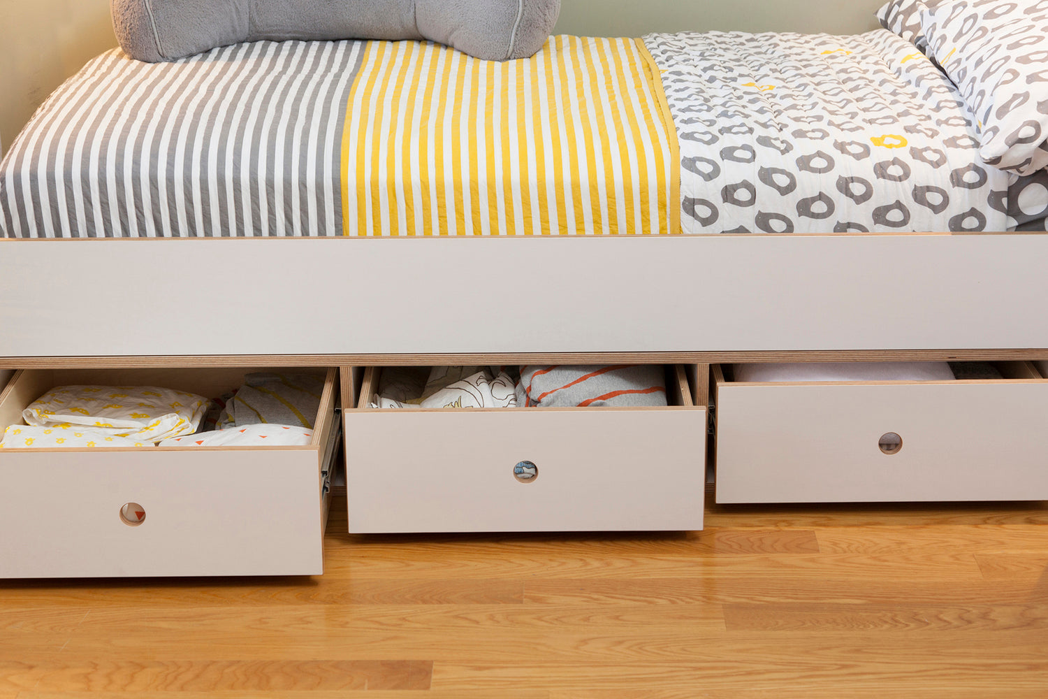 Bed with storage drawers, one open with contents visible.