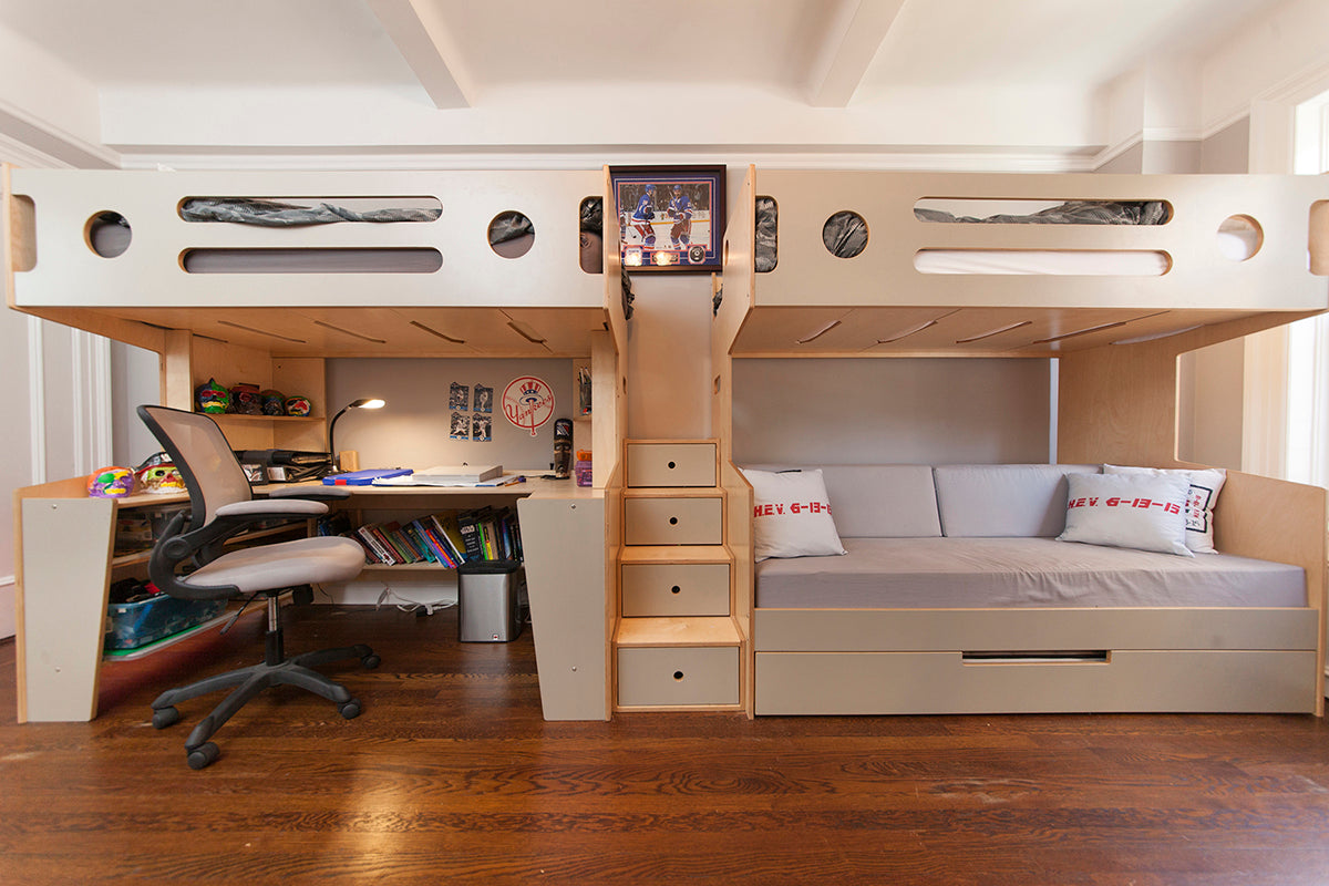 Functional bedroom with a loft bed, desk area, and storage stairs.