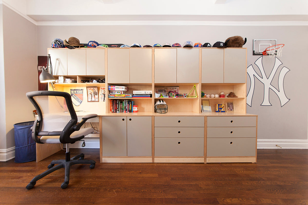 Child's study area with desk, ergonomic chair, and shelving, adorned with sports memorabilia.
