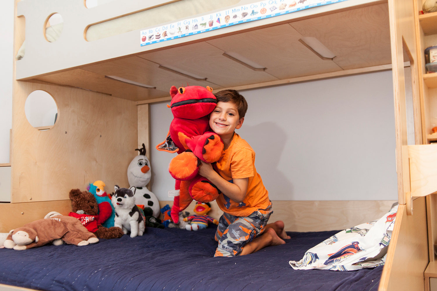 Child on bed with stuffed toys, privacy maintained.