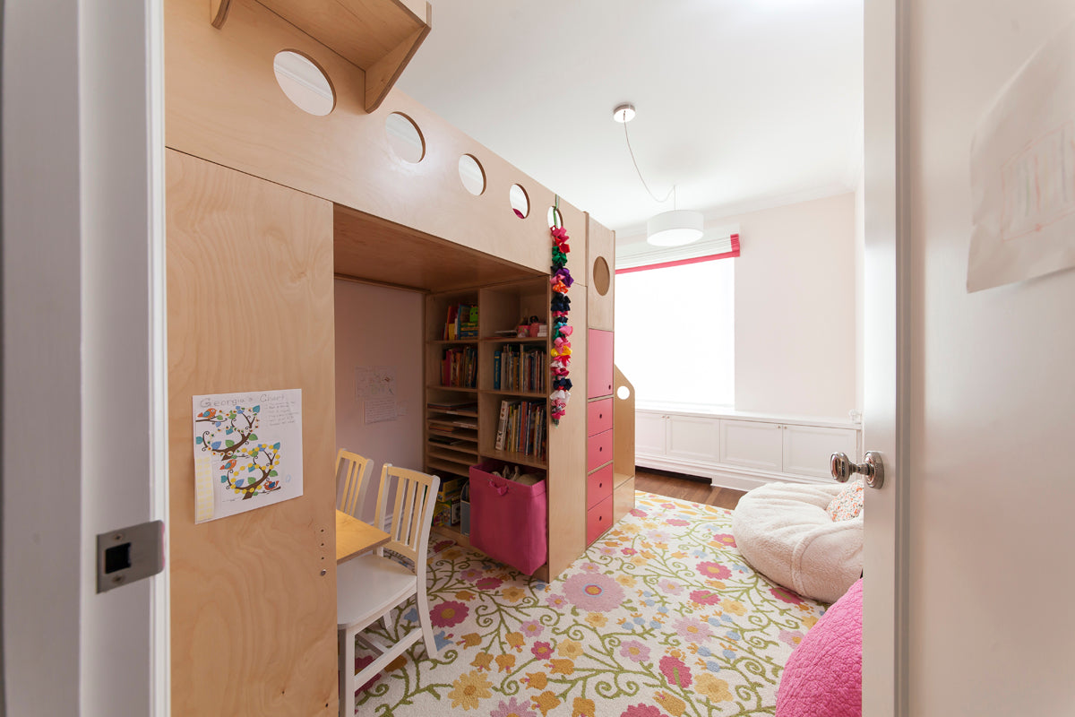 Efficient child’s bedroom with bunk bed, desk, bookshelf, and colorful rug.