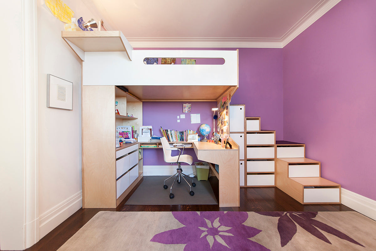 Modern loft bed with desk, stairs, and storage in a purple room.