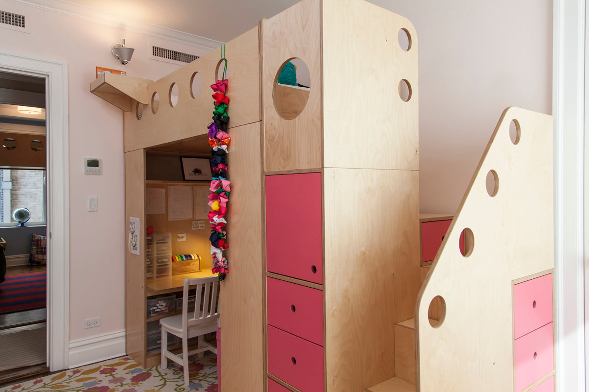 Playful wooden structure with slide, climbing wall, and colorful bins