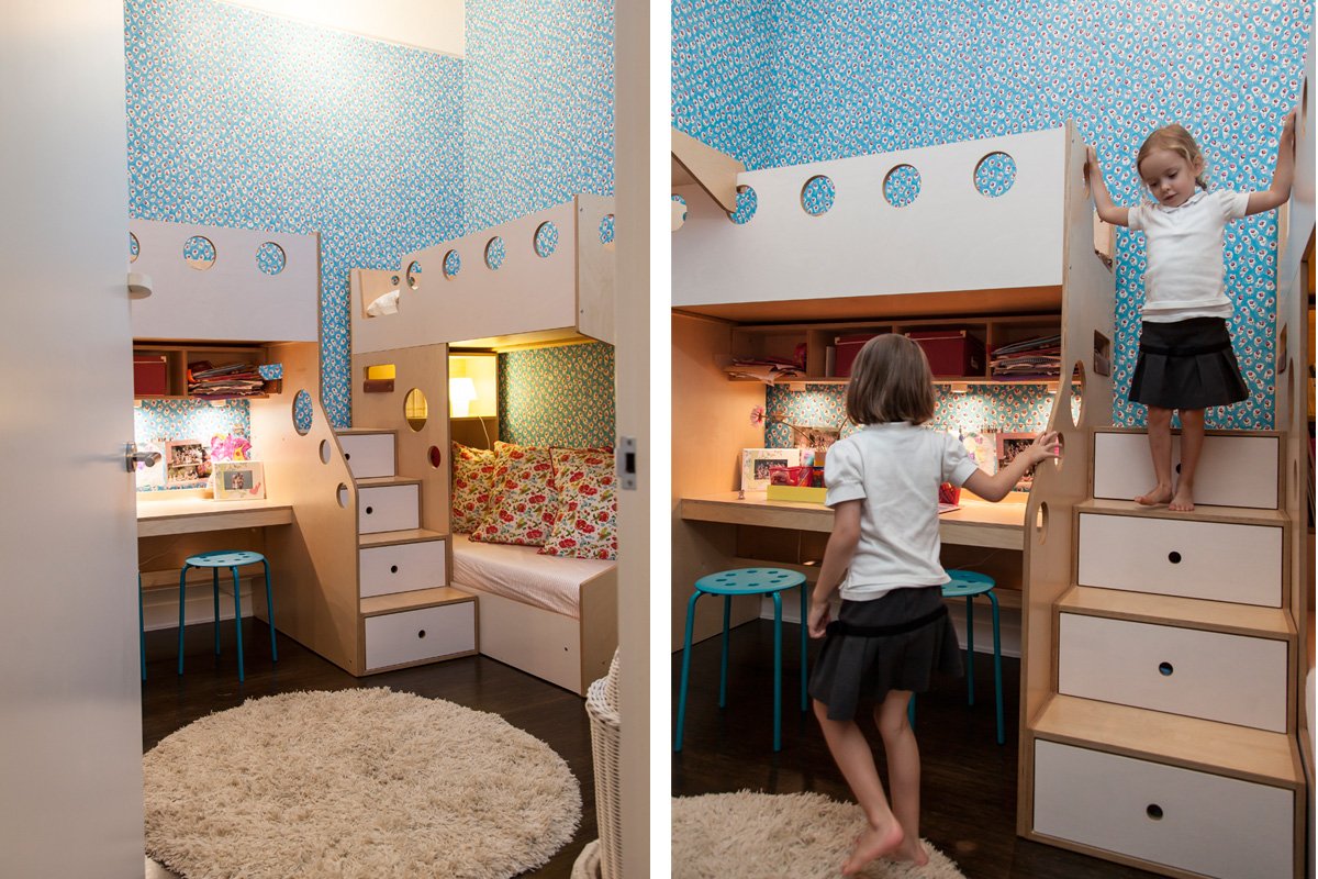 Kids interacting in a colorful room with blue floral wallpaper and a built-in bunk bed setup.