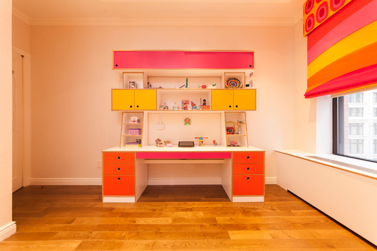 Colorful children’s study space with desk and shelves.