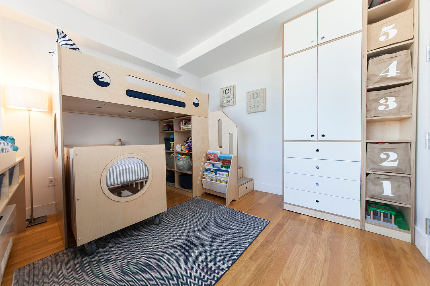 Child’s room with bunk bed, storage, rug, and toys.