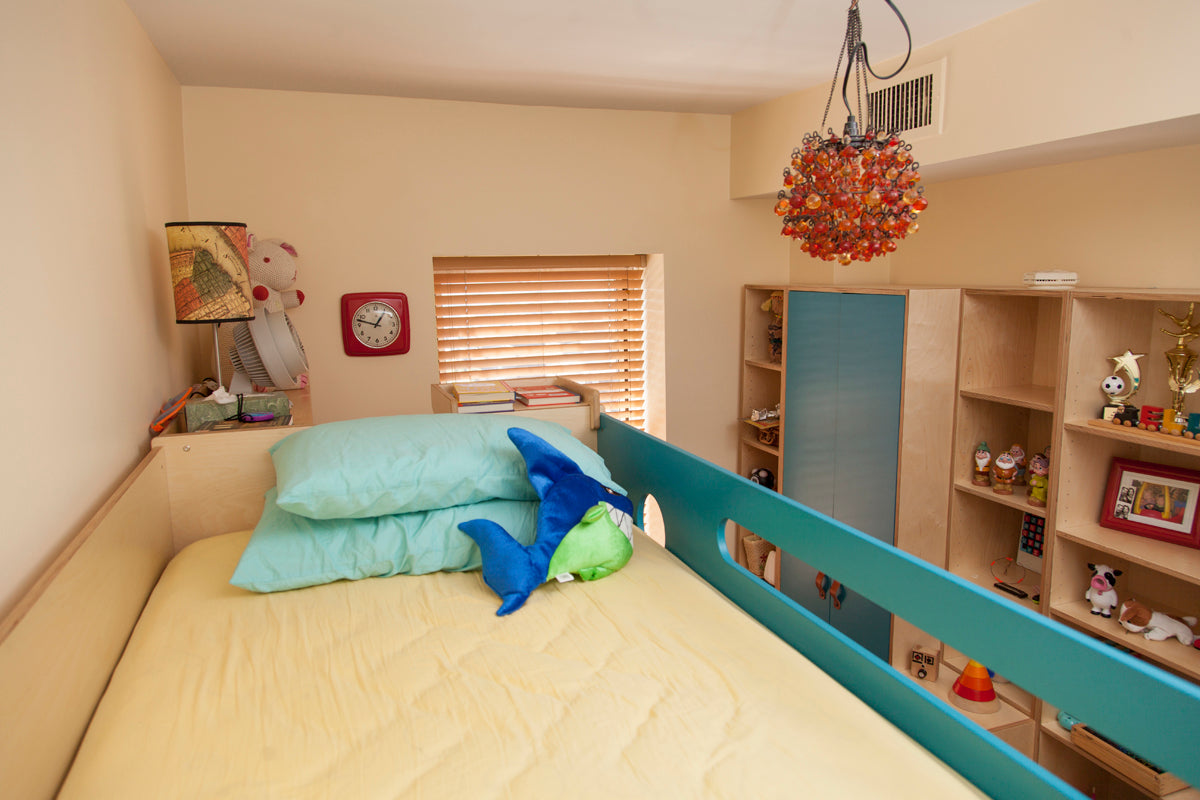 Room with an optical illusion of upside-down furniture, including a bed and shelf.