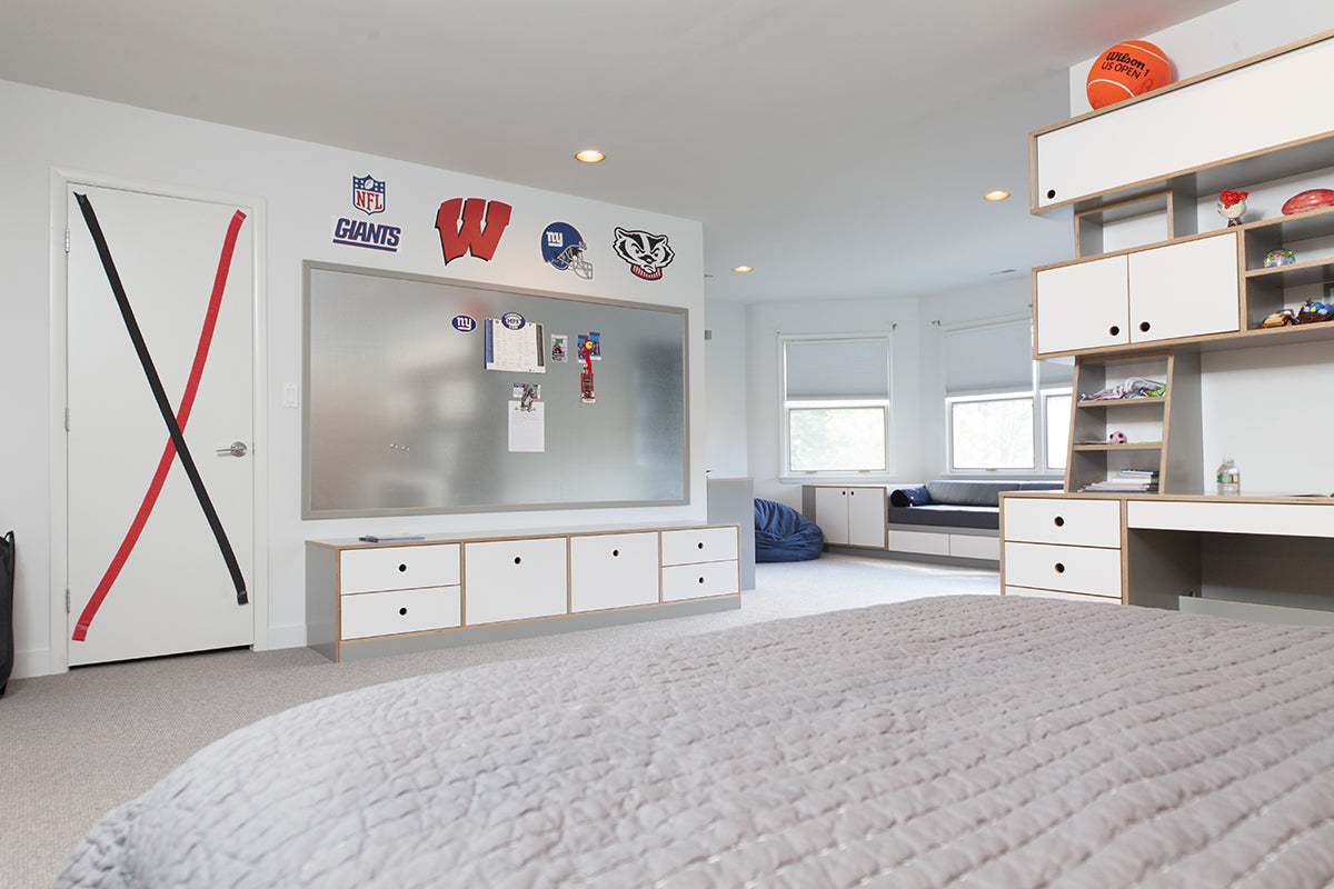  Modern bedroom with sports decor, white furniture, large window.