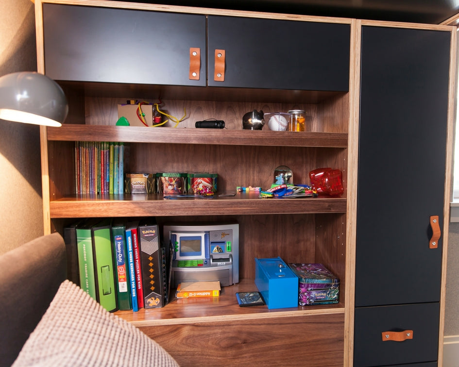 Cozy room with a wooden bookshelf filled with books, games, and colorful items.