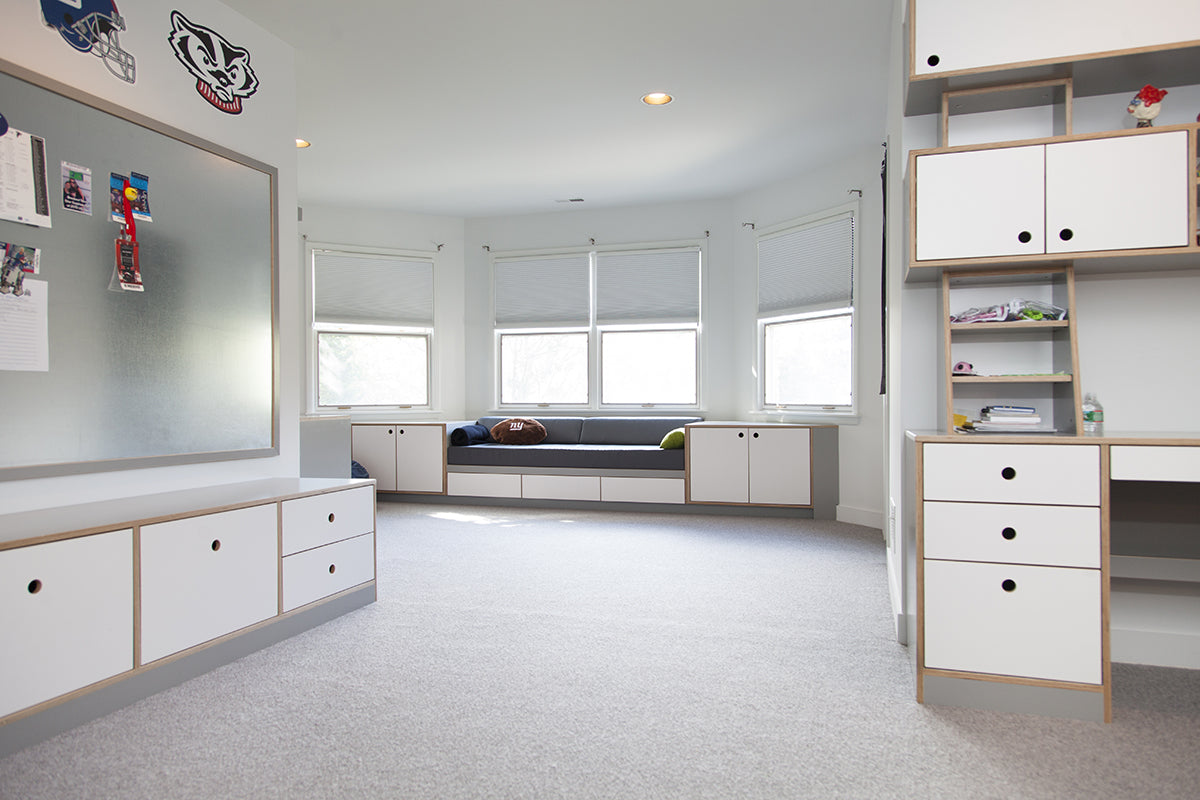 White-walled room with built-in storage and large windows.