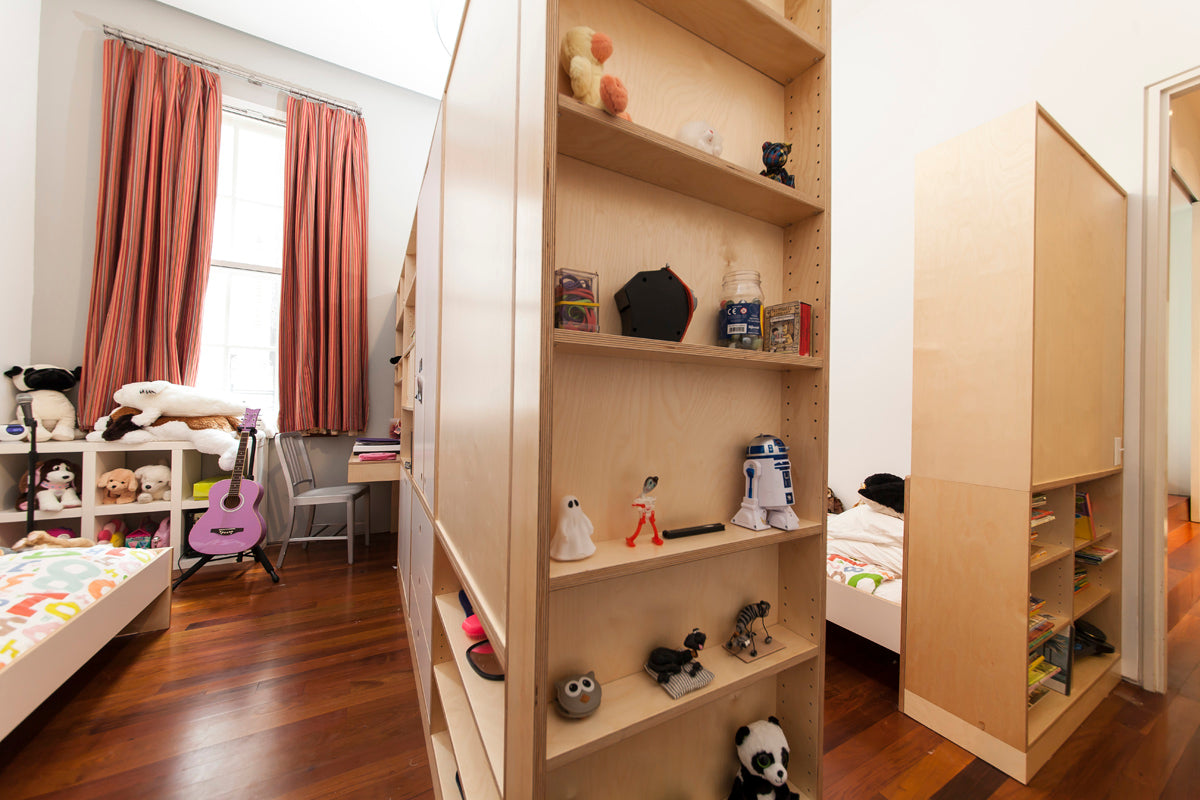 Child’s room with bookshelf, toys, guitar, and mirrored wardrobe.