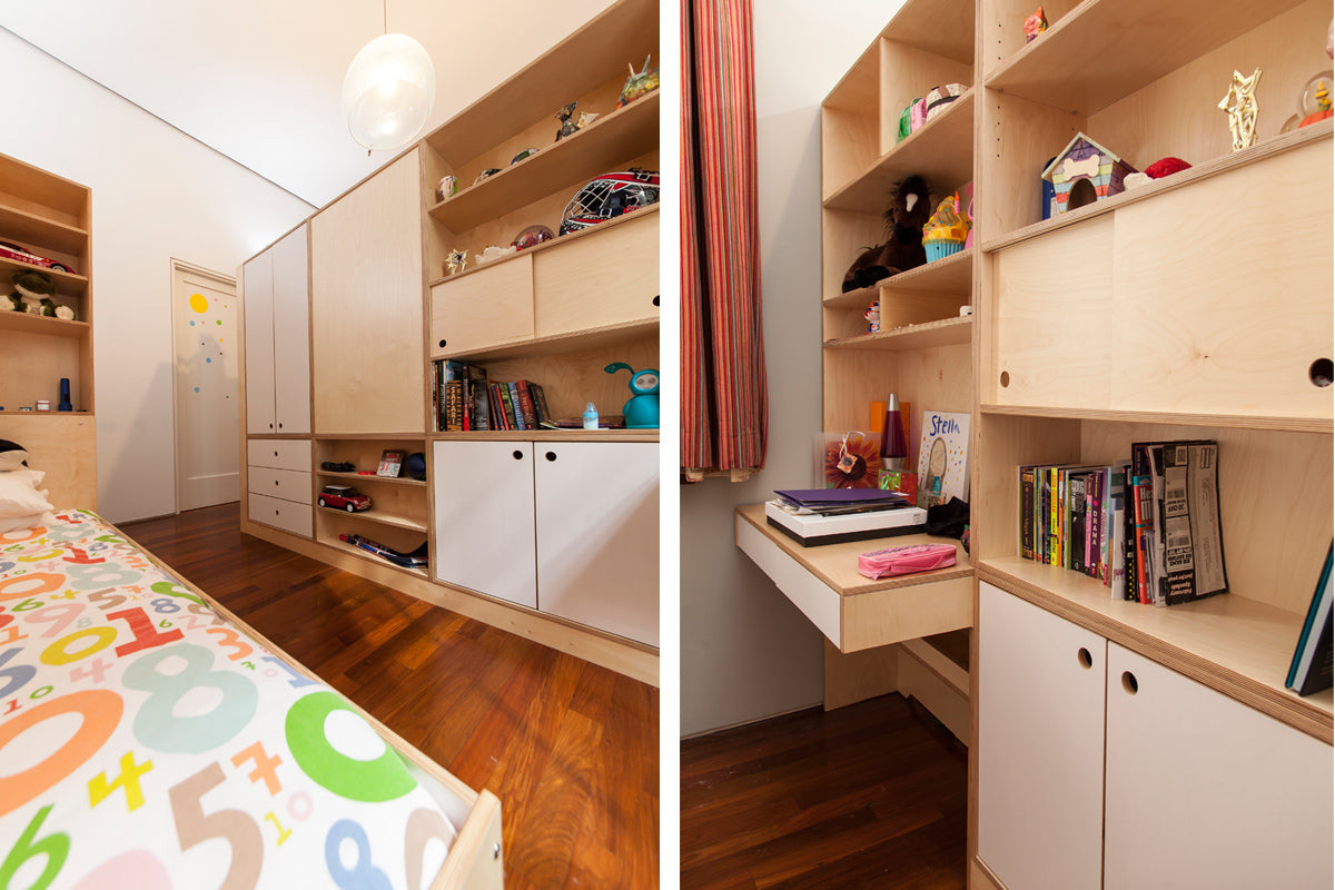 Colorful child’s room with bed, shelves, books, toys, and vibrant decor.