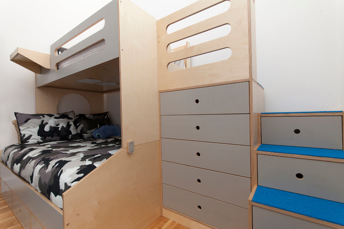 Wooden bunk bed with drawers and blue accents in a child’s room.